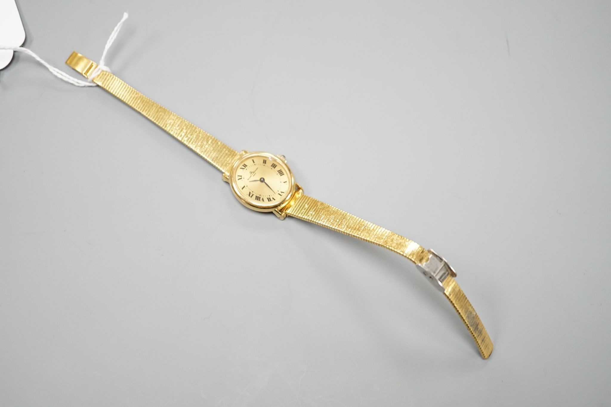 A lady's 18ct gold Baume & Mercier manual wind dress wrist watch, on an associated gold plated bracelet, case diameter 23mm, gross weight 28.3 grams.